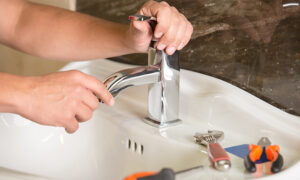 plumbing contractor hands close up installing new bathroom sink faucet elk river mn